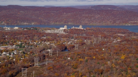 AX119_140.0000056F - Aerial stock photo of Power lines by the Indian Point Nuclear Power Plant in Autumn, Buchanan, New York