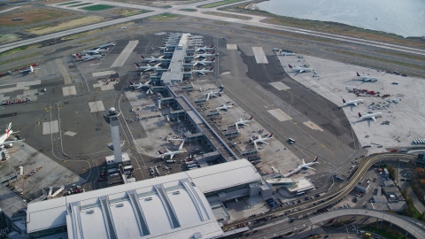 AX120_065.0000103F - Aerial stock photo of Airliners at terminals at John F Kennedy International Airport, New York City