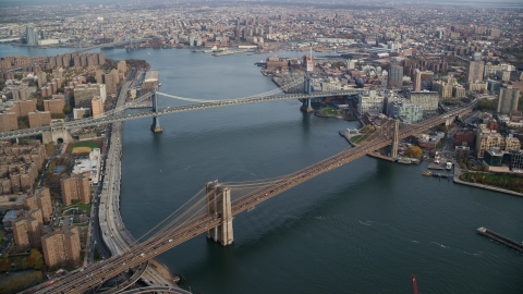 AX120_128.0000261F - Aerial stock photo of Manhattan and Brooklyn Bridges spanning the East River in New York City