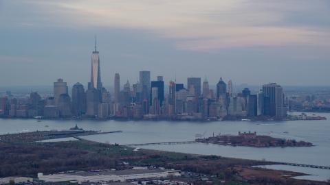 AX121_011.0000090F - Aerial stock photo of Lower Manhattan skyline and Ellis Island at sunset in Autumn, New York City