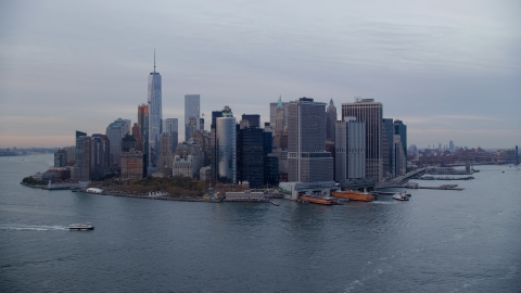 AX121_019.0000105F - Aerial stock photo of Battery Park, downtown skyline, and ferry terminal in Lower Manhattan at sunset, New York City