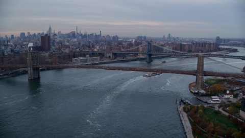 AX121_023.0000020F - Aerial stock photo of The Brooklyn and Manhattan Bridges at sunset in New York City