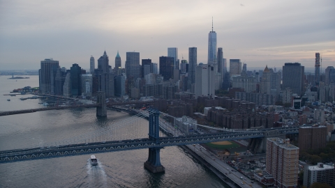 AX121_029.0000120F - Aerial stock photo of The Brooklyn Bridge, Manhattan Bridge, and Lower Manhattan at sunset in New York City