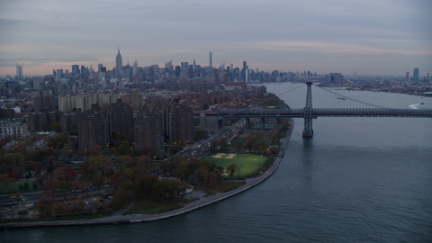 AX121_044.0000009F - Aerial stock photo of Lower East Side projects, the Williamsburg Bridge, and Midtown skyline at sunset in New York City