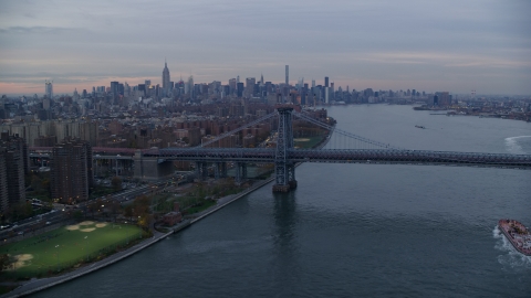 AX121_044.0000169F - Aerial stock photo of Lower East Side public housing, Williamsburg Bridge, and the Midtown skyline at sunset in New York City