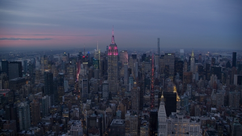 AX121_081.0000239F - Aerial stock photo of Empire State Building with pink lights and Midtown high-rises at Sunset in New York City