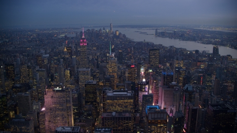 AX121_103.0000219F - Aerial stock photo of Times Square and Midtown skyscrapers with Lower Manhattan in the background at sunset, New York City