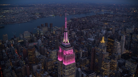 AX121_108.0000073F - Aerial stock photo of The top of Empire State Building at sunset in Midtown, New York City