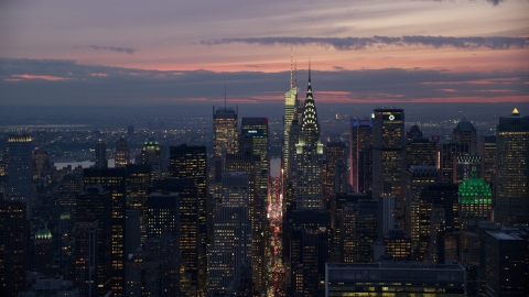 AX121_116.0000185F - Aerial stock photo of Chrysler Building in front of Midtown skyscrapers at sunset, New York City