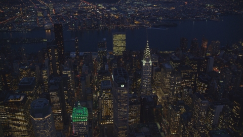 AX121_137.0000031F - Aerial stock photo of The UN and Chrysler Building and Midtown skyscrapers at night in New York City