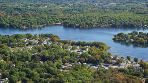 AX143_014.0000107 - Aerial stock photo of A small town by Whitmans Pond in autumn, Weymouth, Massachusetts