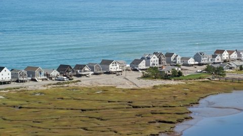 AX143_049.0000000 - Aerial stock photo of A row of elevated oceanfront homes, Humarock, Massachusetts