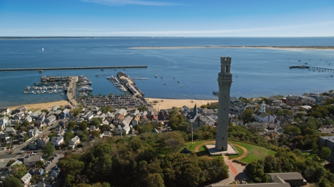 The Pilgrim Monument and small coastal town with a view of piers and the bay, Provincetown, Massachusetts Aerial Stock Photos | AX143_228.0000285