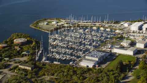 AX145_006.0000321 - Aerial stock photo of Boats at a marina by warehouses in Portsmouth, Rhode Island