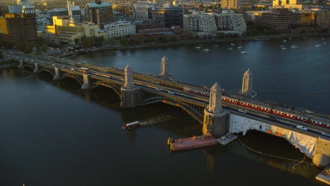 AX146_068.0000149F - Aerial stock photo of A commuter train on Longfellow Bridge in Boston, Massachusetts, sunset