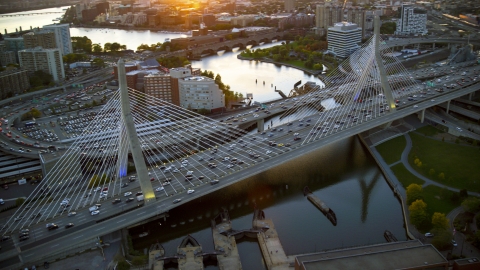 AX146_088.0000269F - Aerial stock photo of Heavy traffic on the Zakim Bridge at sunset in Boston, Massachusetts