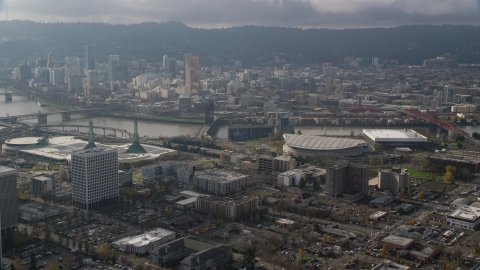 Downtown Portland skyscrapers across the Willamette River from Moda Center in Oregon Aerial Stock Photos | AX153_112.0000199F