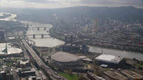 AX153_113.0000312F - Aerial stock photo of Bridges over the Willamette River, skyscrapers in Downtown Portland, and Moda Center in Oregon