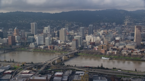 AX153_121.0000355F - Aerial stock photo of Downtown Portland skyscrapers across the Morrison Bridge and the Willamette River, Oregon