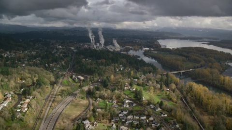 AX153_149.0000054F - Aerial stock photo of High above Highway 14 looking out toward a paper mill in Camas, Washington