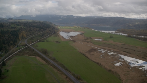 AX153_177.0000272F - Aerial stock photo of Train traveling by fields in Washougal, Washington