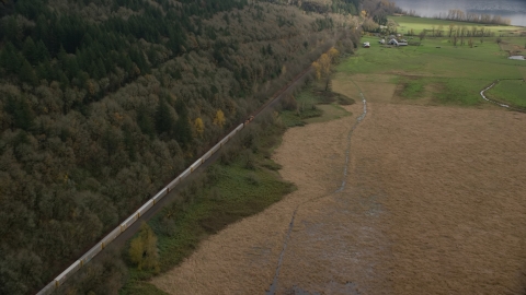 A train traveling by fields and water in Washougal, Washington Aerial Stock Photos | AX153_178.0000352F