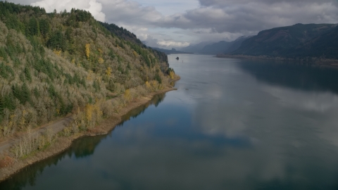 AX154_001.0000308F - Aerial stock photo of Railroad tracks at the bottom of a cliff in the Columbia River Gorge, Oregon