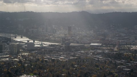 Godrays shining down on Moda Center, the Willamette River and Downtown Portland, Oregon Aerial Stock Photos | AX154_224.0000000F