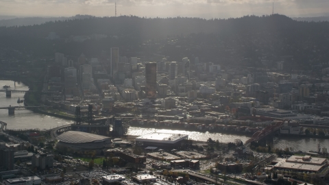 AX154_225.0000228F - Aerial stock photo of Godrays coming down on Moda Center, the Willamette River and Downtown Portland, Oregon