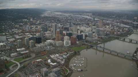 AX155_094.0000000F - Aerial stock photo of A view of Downtown Portland cityscape and waterfront park seen from the bridges over the Willamette River in Oregon