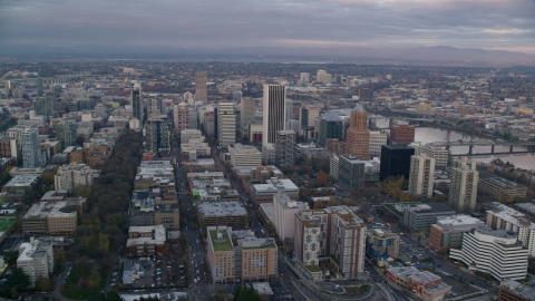 AX155_149.0000211F - Aerial stock photo of Skyscrapers and city streets near the Willamette River at sunset in Downtown Portland, Oregon