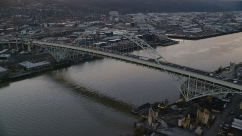 AX155_158.0000038F - Aerial stock photo of Heavy traffic crossing the Fremont Bridge at sunset in Downtown Portland, Oregon