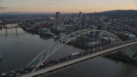 AX155_159.0000302F - Aerial stock photo of Heavy traffic crossing the Fremont Bridge at sunset, near Downtown Portland, Oregon