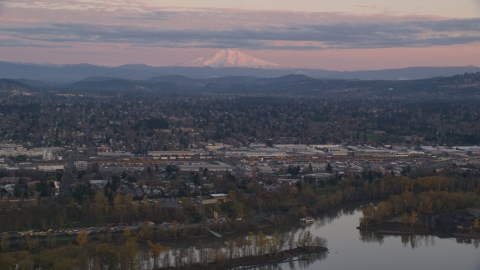 AX155_169.0000000F - Aerial stock photo of Mount Hood in the far distance at sunset, seen from a train yard in Southeast Portland, Oregon