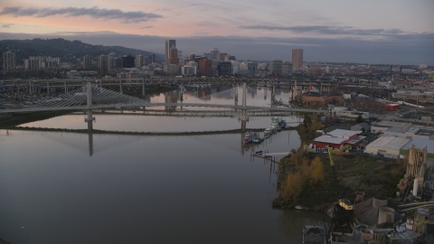 AX155_199.0000000F - Aerial stock photo of Tilikum Crossing, Marquam Bridge, and downtown skyline at sunset, Downtown Portland, Oregon