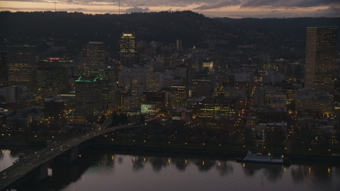 AX155_253.0000309F - Aerial stock photo of Skyscrapers and the Morrison Bridge over the Willamette River at sunset, Downtown Portland, Oregon