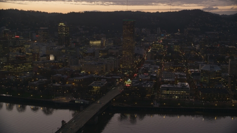 AX155_254.0000344F - Aerial stock photo of US Bancorp Tower, Burnside Bridge over the Willamette River, and White Stag Sign at sunset, Downtown Portland, Oregon