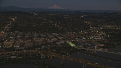 AX155_266.0000105F - Aerial stock photo of Mount Hood in the far distance, and warehouse buildings near the Willamette River, Southeast Portland, Oregon, sunset