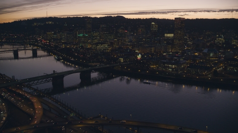 AX155_278.0000359F - Aerial stock photo of Freeway interchange, Willamette River, Burnside Bridge, and Downtown Portland, Oregon at sunset