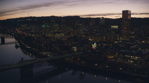 AX155_279.0000343F - Aerial stock photo of The Willamette River, Burnside Bridge, White Stag sign, and Downtown Portland at sunset, Oregon