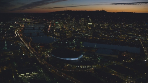 AX155_308.0000296F - Aerial stock photo of Downtown Portland and Willamette River at night seen from Moda Center in Oregon