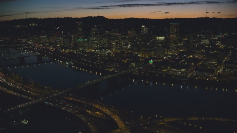 AX155_316.0000329F - Aerial stock photo of A view across the Willamette River of Downtown Portland and the White Stag Sign, Oregon, at night