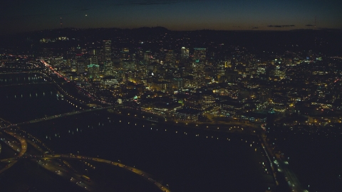 AX155_362.0000258F - Aerial stock photo of US Bancorp Tower, White Stag sign across Willamette River, Burnside Bridge, Steel Bridge, night, Downtown Portland, Oregon