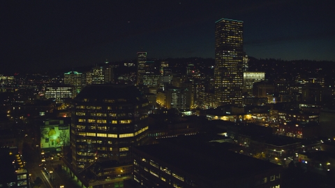 AX155_368.0000040F - Aerial stock photo of One Pacific Square, with US Bancorp Tower and high-rises in the background at night, Downtown Portland, Oregon