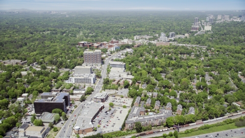 AX36_046.0000119F - Aerial stock photo of Office buildings and wooded areas, skyscrapers in the distance, Buckhead, Georgia