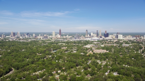 AX37_006.0000258F - Aerial stock photo of Midtown and Downtown Atlanta seen from above the trees in West Atlanta, Georgia