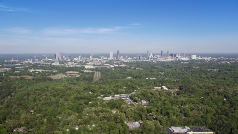 AX38_003.0000095F - Aerial stock photo of Midtown and Downtown from over forests, Atlanta, Georgia