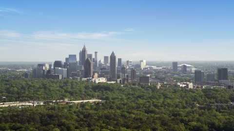 AX38_028.0000097F - Aerial stock photo of Midtown Atlanta skyscrapers beyond trees, Buckhead, Georgia