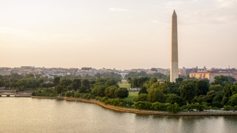 AXP076_000_0010F - Aerial stock photo of The Washington Monument and White House seen from Tidal Basin, Washington D.C., sunset