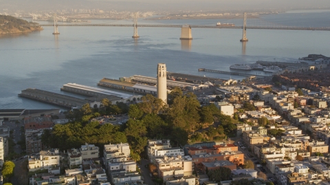 DCSF07_008.0000069 - Aerial stock photo of Coit Tower with Bay Bridge in background, North Beach, San Francisco, California, sunset